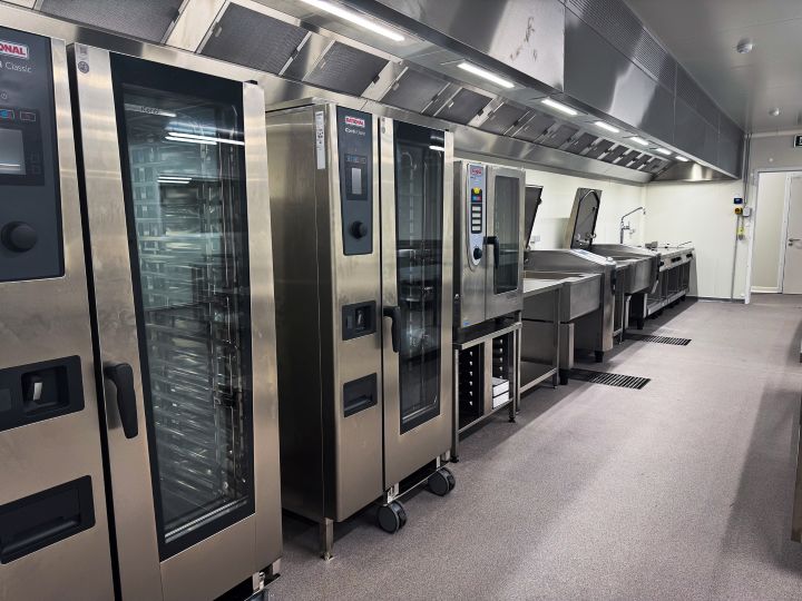Professionele keukenlijn met ovens, kooktoestellen en dampkap