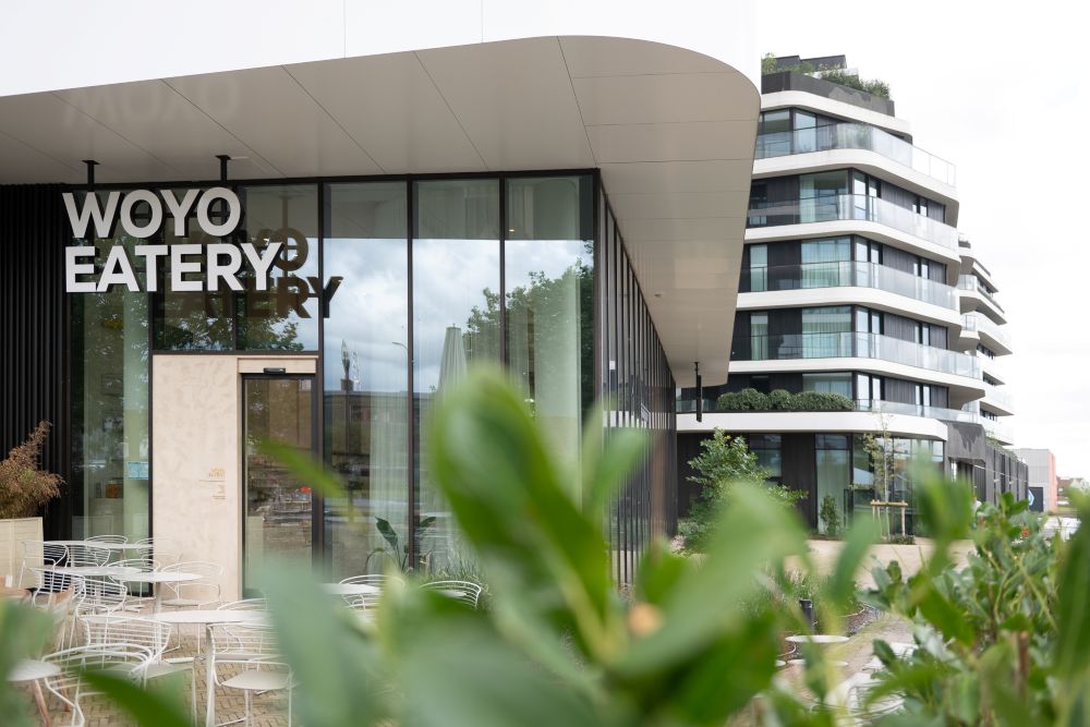 Gevel van Woyo Eatery in Knokke met terras en moderne architectuur.